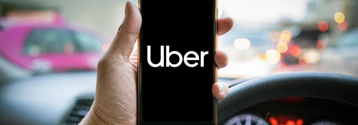 An Uber driver using his phone, looking for compensation claims