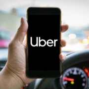 An Uber driver using his phone, looking for compensation claims