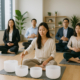 Employees in a Singapore corporate wellness program participating in a guided sound bath and mindfulness session inside a bright, calming office space.