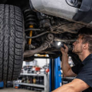 Mechanic inspecting suspension under silver SUV best suspension in Perth