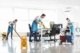 Professional cleaners providing Office Clean Out Services Kent WA in a modern, bright office space with cleaning supplies, vacuums, and "Wet Floor" signage.