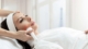 Woman receiving a professional skin tightening facial near Tysons Corner using a handheld device in a spa setting.