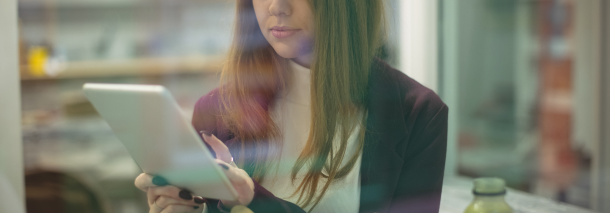 Woman using a digital tablet while eating salad, symbolizing how modern consumers engage with brands and build trust online.