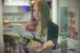 Woman using a digital tablet while eating salad, symbolizing how modern consumers engage with brands and build trust online.